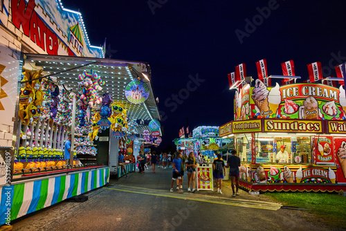 Nighttime at carnival county fair with vendors of games and food