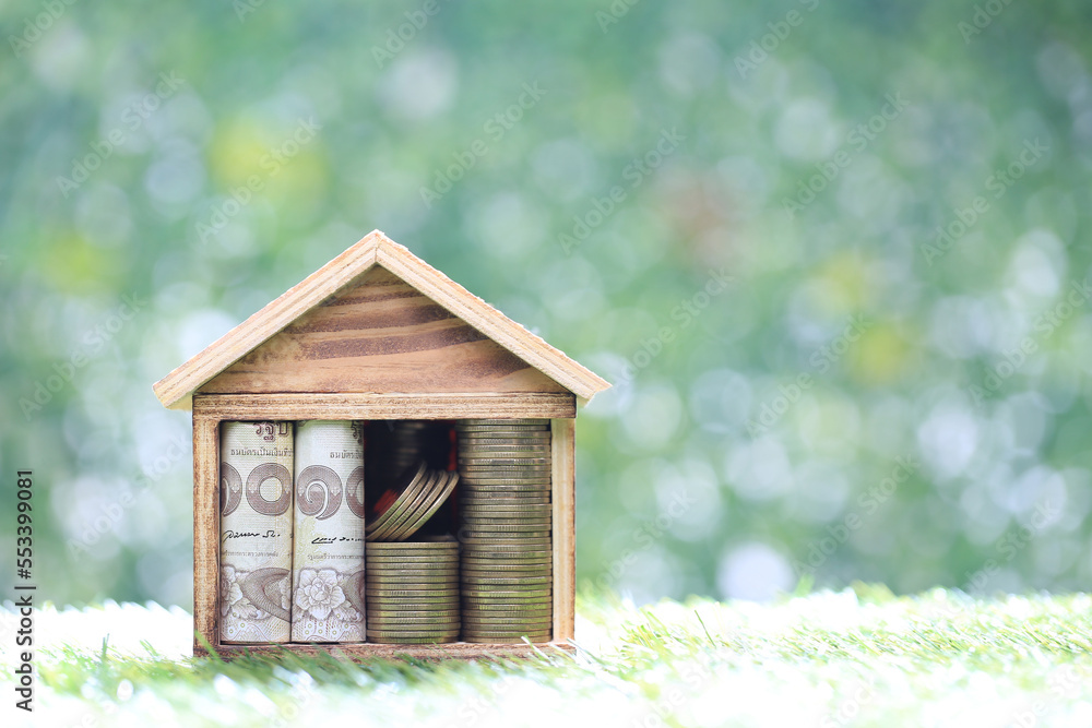 Mortgage,Money in model house on natural green background,Business investment and real estate concept Mortgage,Money in model house on natural green background,Business investment and real estate concept