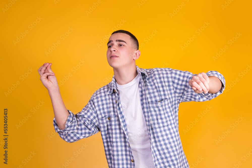 A handsome guy in a checkered shirt on a yellow background A handsome guy in a checkered shirt on a yellow background
