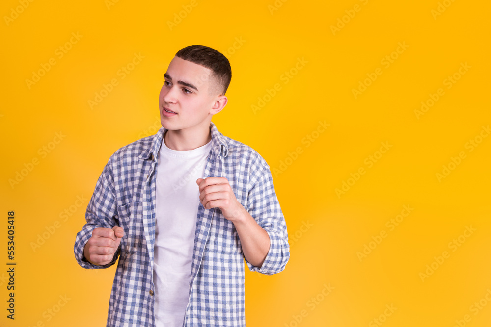 A handsome guy in a checkered shirt on a yellow background A handsome guy in a checkered shirt on a yellow background