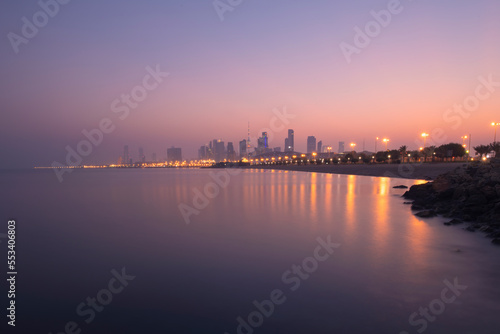 View of the Kuwait skyline - with the best known landmark of Kuwait City - during sunrise and beach view. Kuwait city skline from bridge with slow shutter speed.