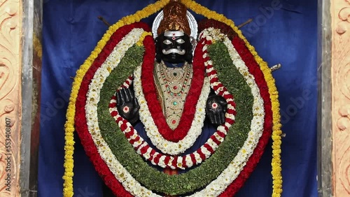 Closeup of Shaneshwara Swamy god statue with decoration photo
