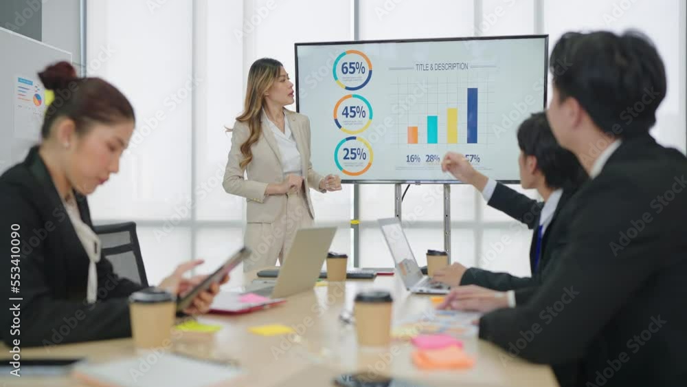 Asian businesswoman leader uses presentation on TV show the statistics and graph with businesspeople group office meeting Asian businesswoman leader uses presentation on TV show the statistics and graph with businesspeople group office meeting