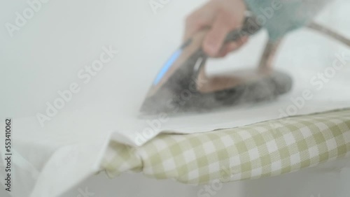 woman Hand ironing a white shirt with the steam iron on an ironing board at home. Fast ironing. close up. 4k. High quality 4k footage