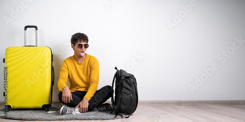 Dissatisfied tourist traveler male frowns face, has disgusting expression, shows tongue, expresses non compliance, irritated with somebody. Travel, people and negative facial expressions photo