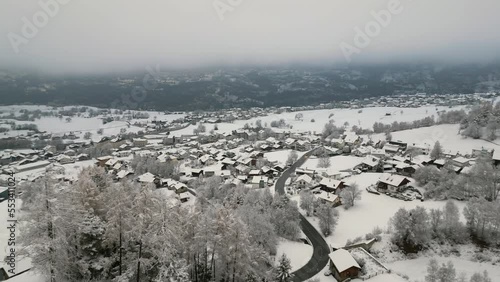 Small snowy Swiss mountain village in winter. Ried Brig and Termen. Aerial Shot photo