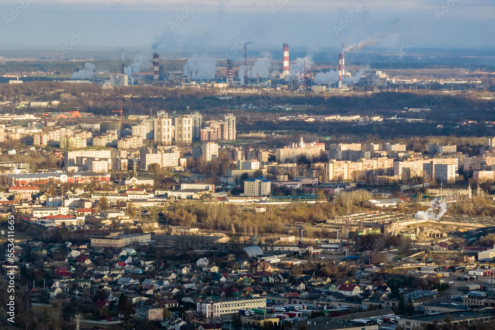 ariel panoramic view of city with huge factory with smoking chimneys in the background