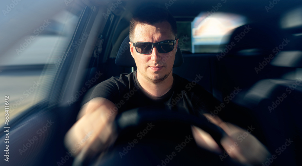 The man is driving a car. The man is driving a car.