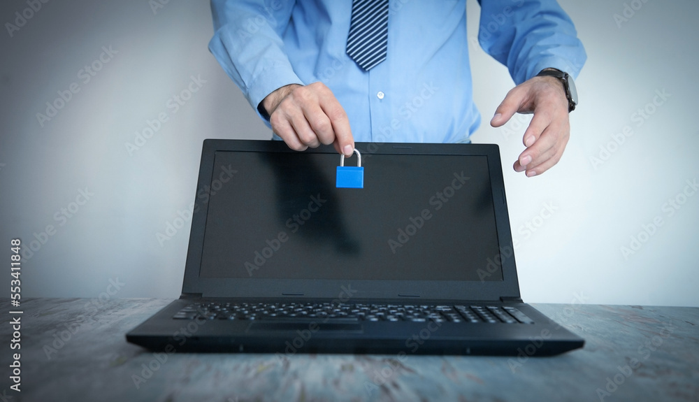 Male hand holding padlock on laptop computer. Data protection Male hand holding padlock on laptop computer. Data protection