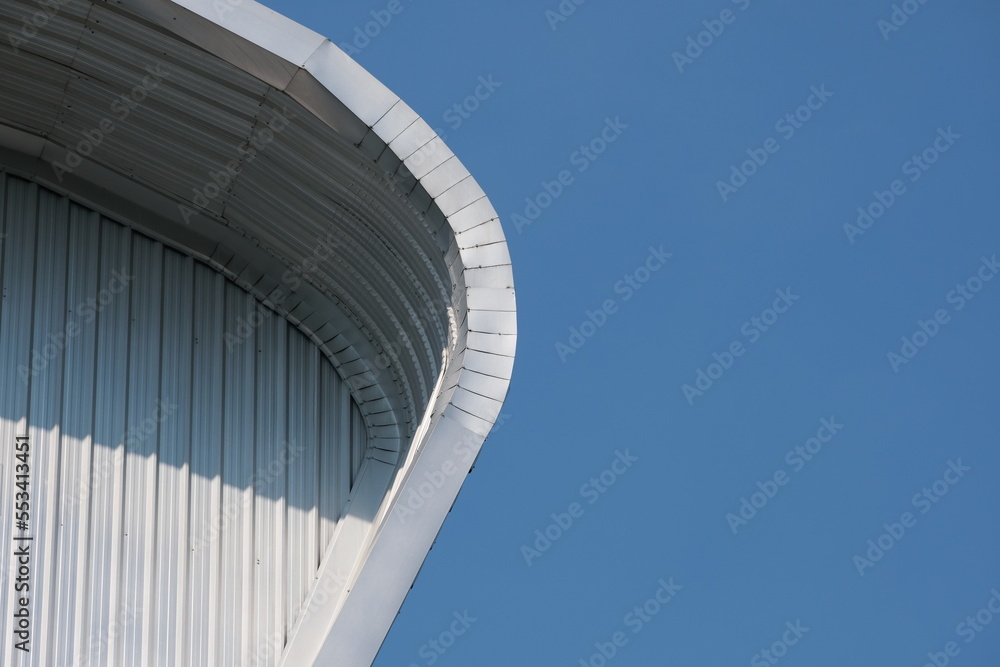Fototapeta premium Sunlit corrugated facade against blue sky