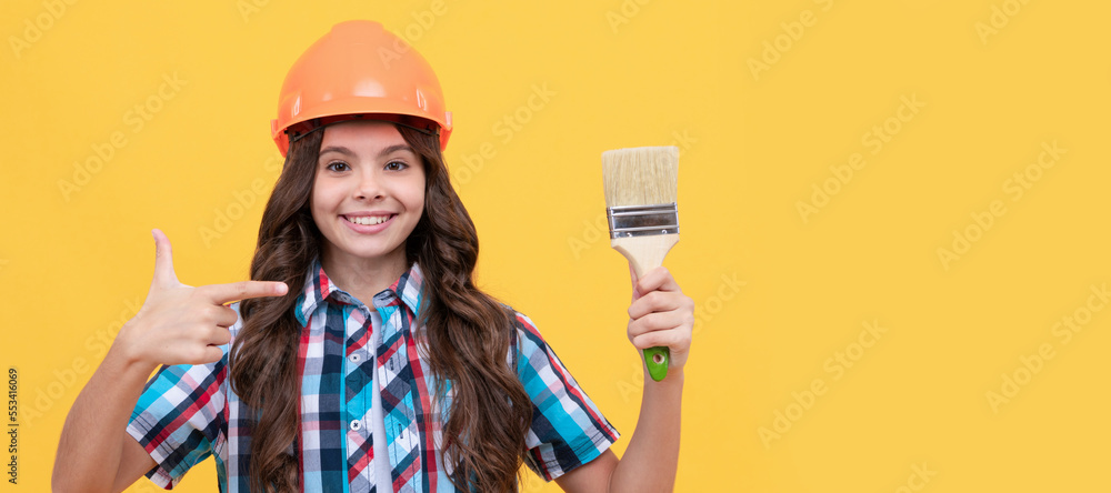 Builder teenager girl in helmet. happy child with curly hair in construction helmet pointing finger on painting brush, renovation. Child builder in helmet horizontal poster design. Banner header, copy Builder teenager girl in helmet. happy child with curly hair in construction helmet pointing finger on painting brush, renovation. Child builder in helmet horizontal poster design. Banner header, copy