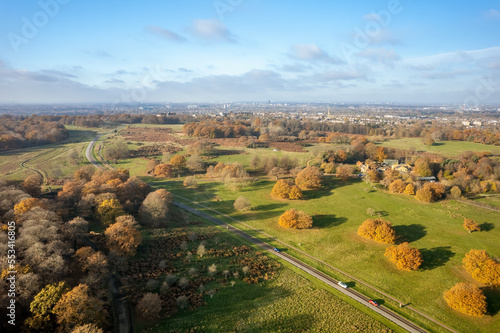 Aerial view of Richmond Park in autumn with city of London in the background.  Richmond Park  in the London Borough of Richmond upon Thames  is the largest of London s Royal Parks.