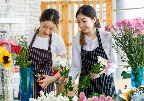 Foto Millennial Asian young female flower shopkeeper decorator florist worker in apro