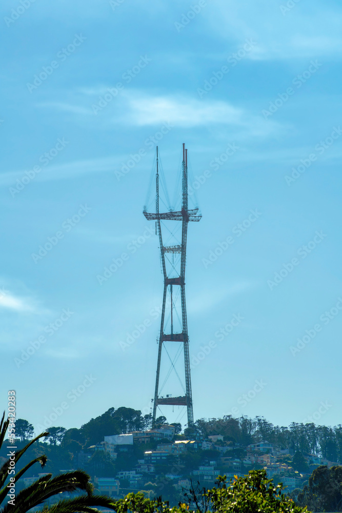 Sutro tower in shadow with urban and suburban foreground with clear blue sky background some clouds in the city neighborhood