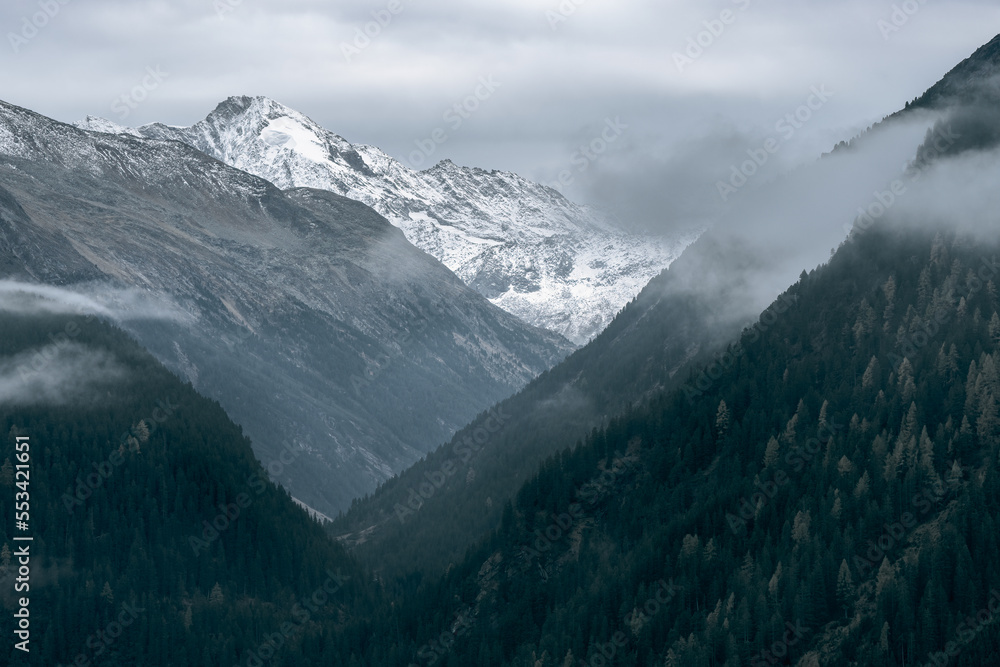 Dreiherrnspitze, Picco dei Tre Signori mountain in the back with dramatic mountain slopes on a cloudy and rainy day in Austrian-Italian Alps. Snow and glaciers n the top of Alpine mountain. Krimmler.