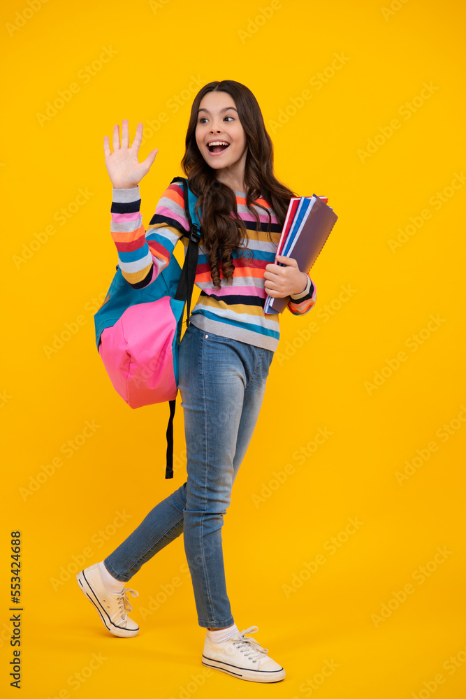 Amazed teenager. Schoolgirl, teenage student girl hold book on yellow isolated studio background. School and education concept. Back to school. Excited teen girl. Amazed teenager. Schoolgirl, teenage student girl hold book on yellow isolated studio background. School and education concept. Back to school. Excited teen girl.
