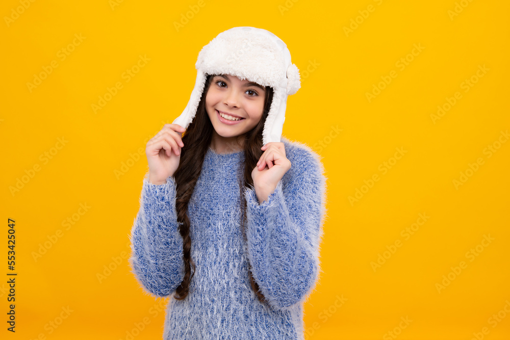 School girl in winter clothes and warm hat. Winter holiday vacation. Child fashion model. Happy teenager, positive and smiling emotions of teen girl.