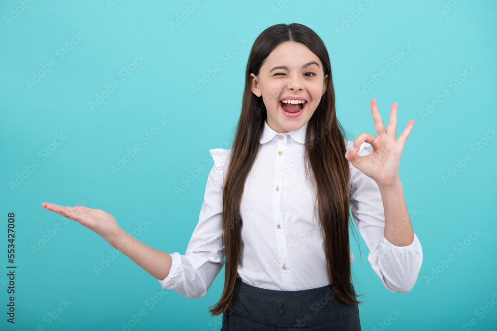 Excited face. Amazed expression, cheerful and glad. Positive teenager child points aside with cheerful expression, shows amazing at blank empty space. Advertisement and mockup. Excited face. Amazed expression, cheerful and glad. Positive teenager child points aside with cheerful expression, shows amazing at blank empty space. Advertisement and mockup.
