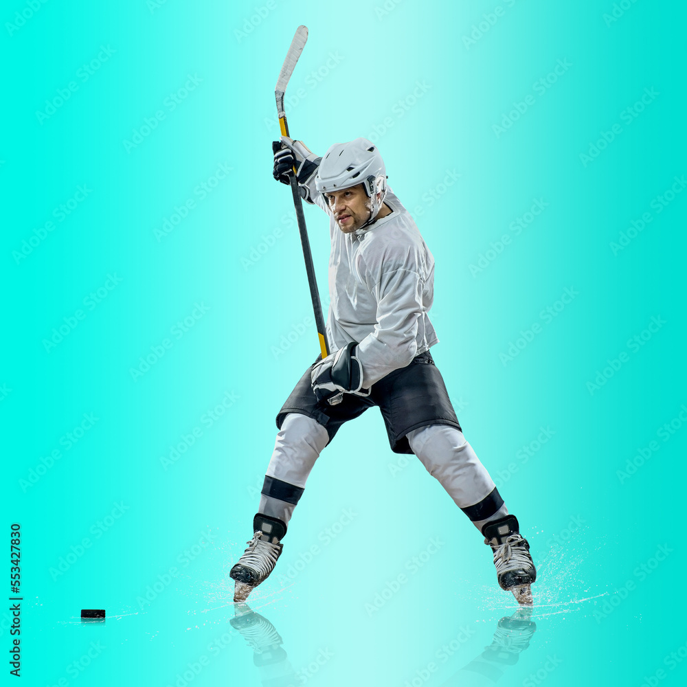 Professional ice hockey player hitting puck for winning goal in action on gradient multicolored neon background. Concept of sport competition. Professional ice hockey player hitting puck for winning goal in action on gradient multicolored neon background. Concept of sport competition.