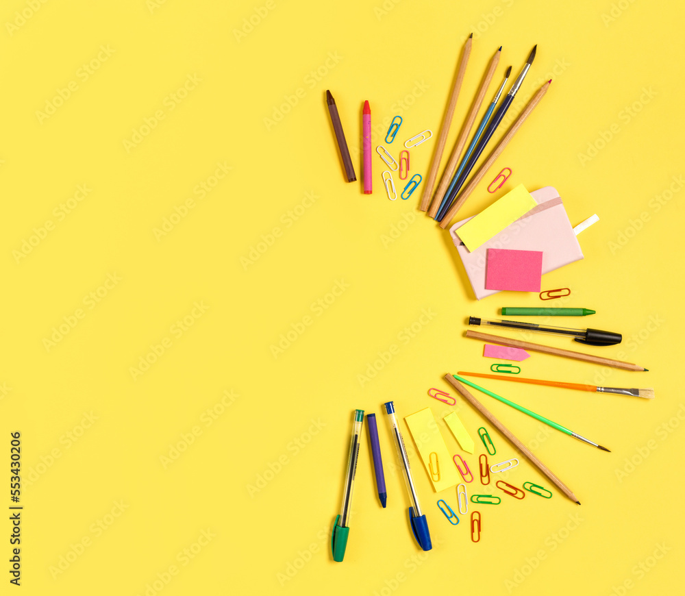 Various office stationery items on a bright yellow background with copy space top view. Creative background