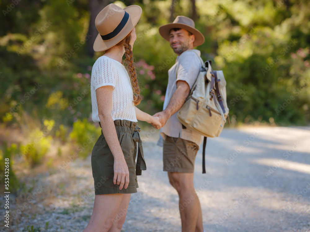 Obraz premium concept of embracing fresh air and engaging in outdoor activities. Loving young couple hugging and smiling together on nature background. Mountains Forest walk in Turkey. follow me