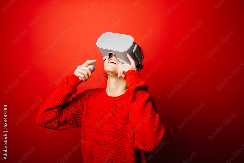 Studio portrait of a pre-adolescent boy with virtual reality glasses over a red background Studio portrait of a pre-adolescent boy with virtual reality glasses over a red background