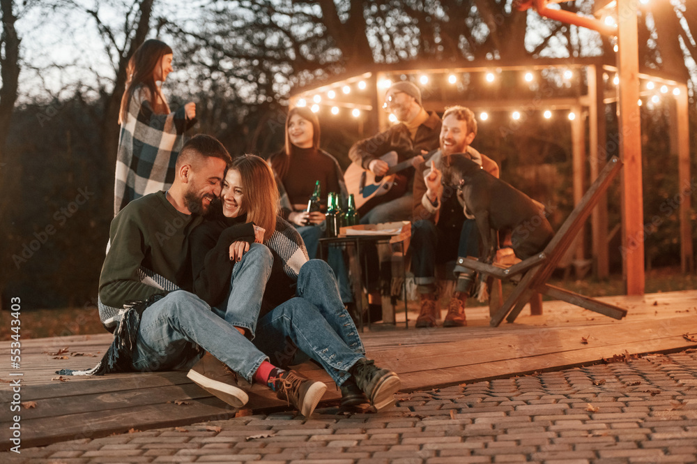 Obraz premium Lovely couple. Group of people is spending time together on the backyard at evening time