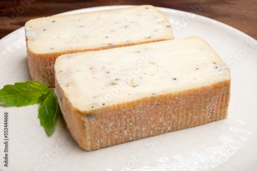 Foto Italian cheese collection, yellow taleggio cheese with black truffles mushrooms