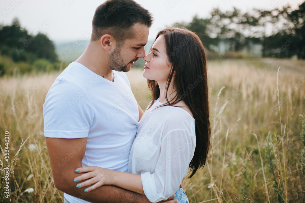 Happy in love romantic young cheerful couple man and woman walk together among the summer forest Happy in love romantic young cheerful couple man and woman walk together among the summer forest