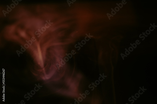 Sexy swirls of red incense smoke isolated from black background. Close-up of vapor. Soft focus and texture from vintage Helios 44m-4 lens. Abstract graphic design asset. Horizontal copy space.
