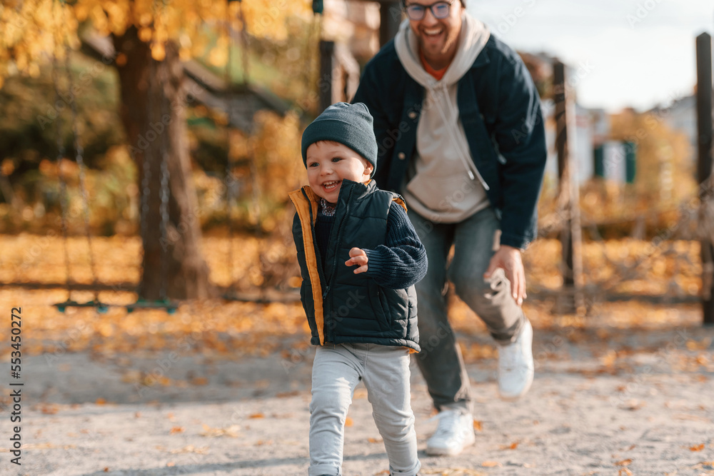 Obraz premium Playing, having fun together. Father and young son is together outdoors at daytime