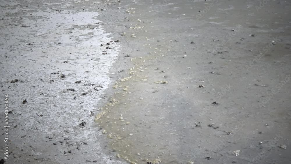 The wind quickly rolls small waves and foam onto the coastline in the shallow waters of the Kuyalnitsky Estuary The wind quickly rolls small waves and foam onto the coastline in the shallow waters of the Kuyalnitsky Estuary