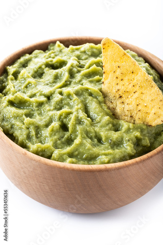 Mexican guacamole with nacho chip in wooden bowl isolated on white background