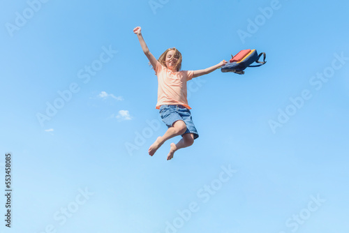 Banner with Girl in a jump against the blue sky with a school bag. Happy summer.