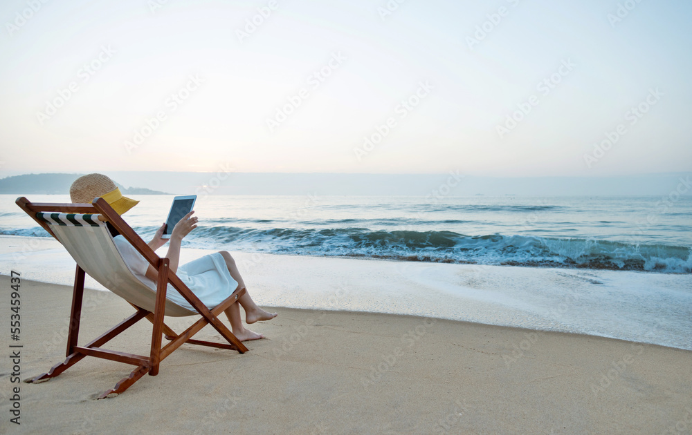 Young woman holding digital tablet at the beach. Young woman holding digital tablet at the beach.