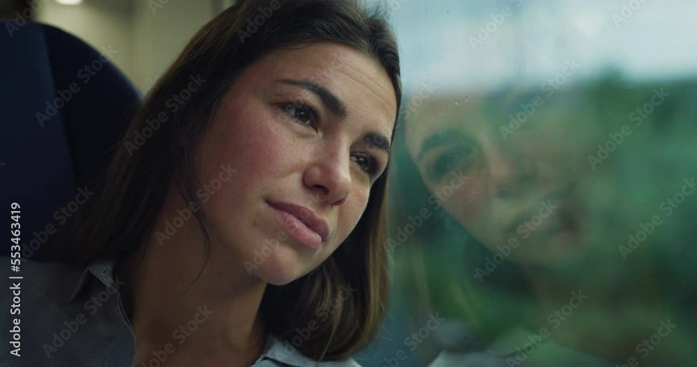 Cinematic Close Up shot of Young Woman Looking Through Window While Traveling by Train Through Green Landscape. Nostalgic Female Feeling Homesick and Smiling While Reaching her Station