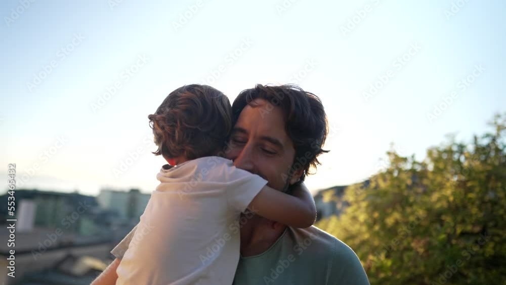 Child embracing father in sunset time. Father and son bonding moment during Golden Hour Time. Parent and small boy hug. Fatherhood concept Child embracing father in sunset time. Father and son bonding moment during Golden Hour Time. Parent and small boy hug. Fatherhood concept