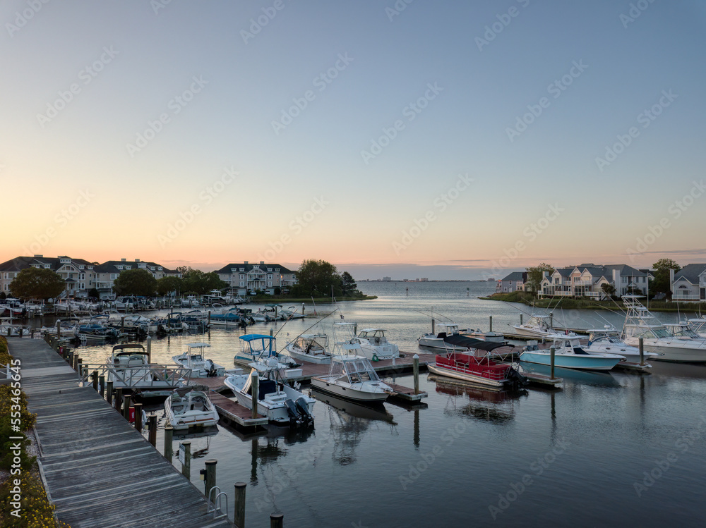 Sunrise over a marina with Ocean City, Maryland off in the distance.