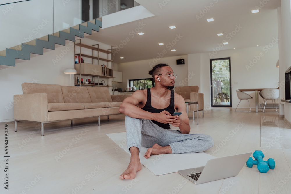 Training At Home. Sporty man doing training while watching online tutorial on laptop, exercising in living room, free space. Training At Home. Sporty man doing training while watching online tutorial on laptop, exercising in living room, free space.