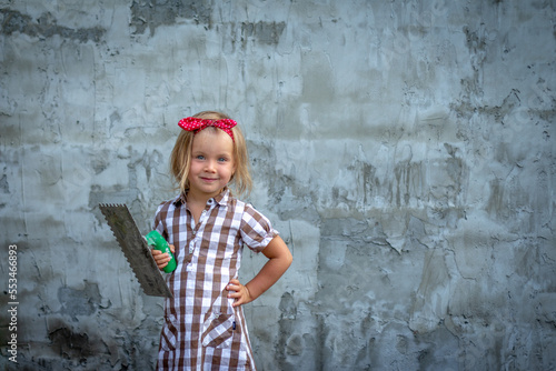 Fotografie Cute little plasterer girl with a spatula