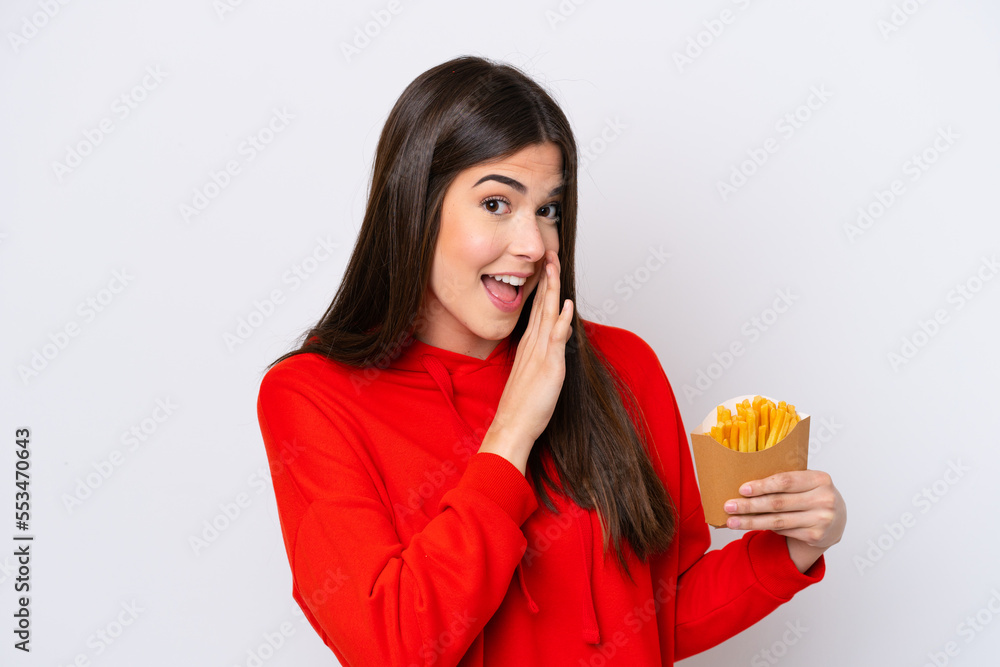 Young Brazilian woman catching french fries isolated on white background whispering something