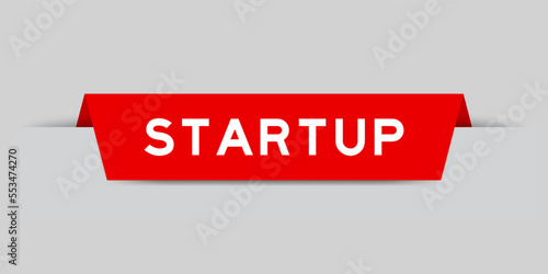 Red color inserted label with word startup on gray background