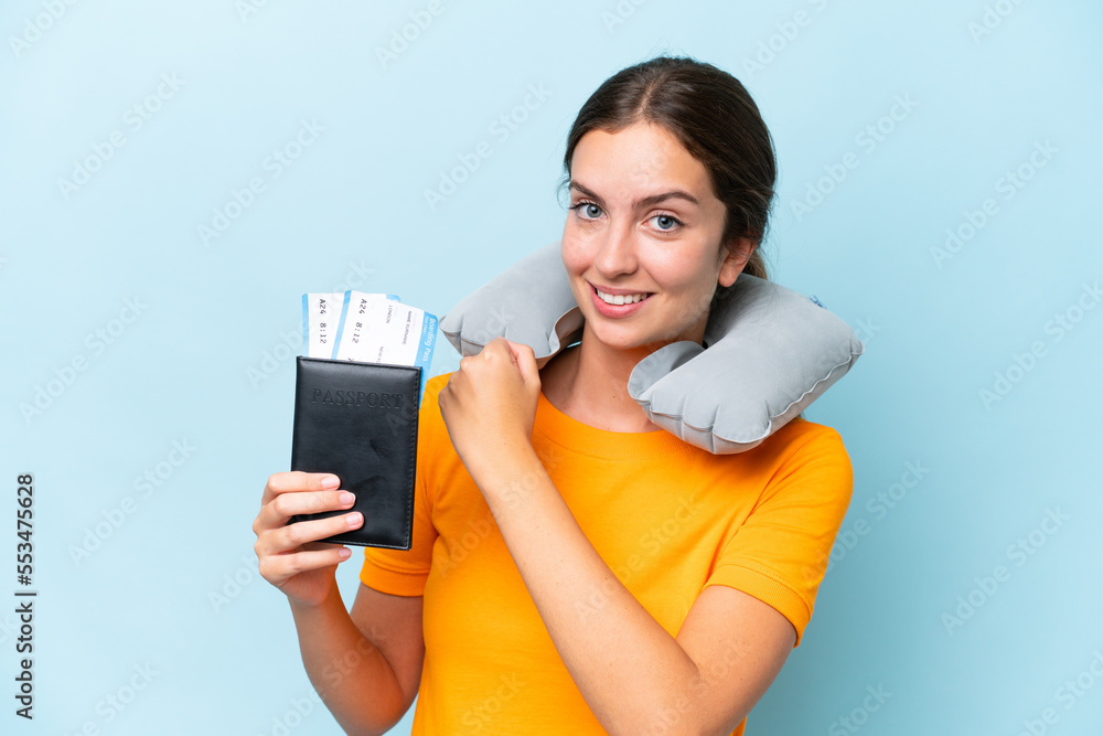 Young beautiful woman with Inflatable travel Pillow isolated on blue background celebrating a victory Young beautiful woman with Inflatable travel Pillow isolated on blue background celebrating a victory