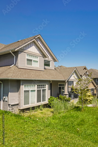 Suburban residential house with green lawn in front © Imagenet
