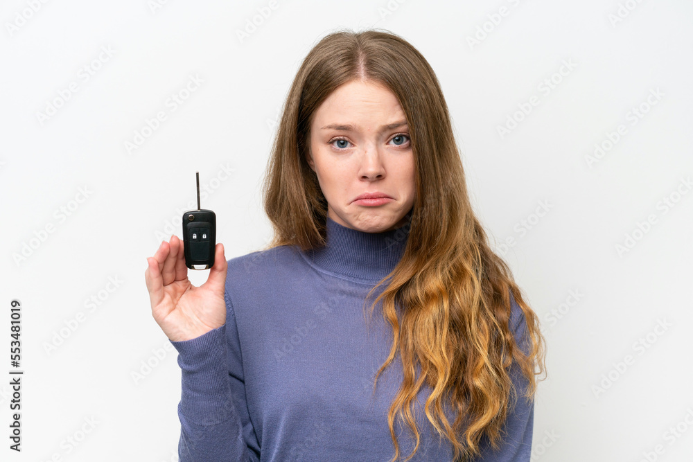 Young caucasian woman holding car keys isolated on white background with sad expression Young caucasian woman holding car keys isolated on white background with sad expression