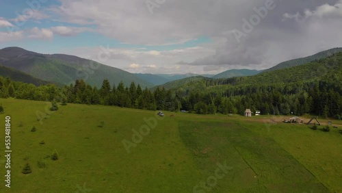 Aerial distance view on the top of the mountain pass, a man alone, are enjoying the nature. A tourist tent and a SUV vehicle with a roof rack. freedom and travel by car, Kolochava, Ukraine photo