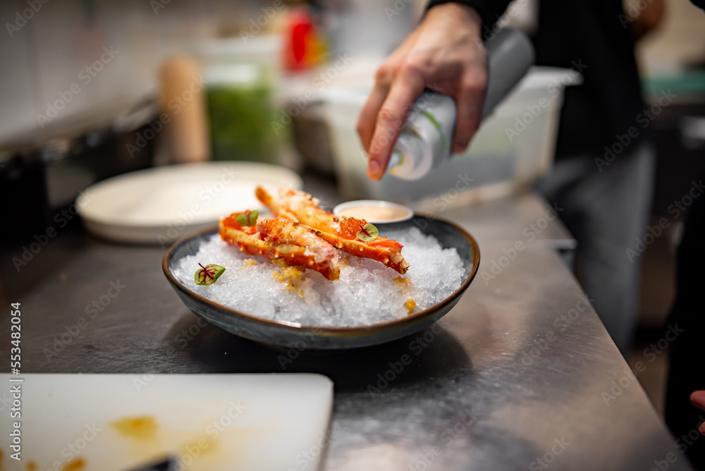 chef cooking crab legs with caviar on kitchen chef cooking crab legs with caviar on kitchen