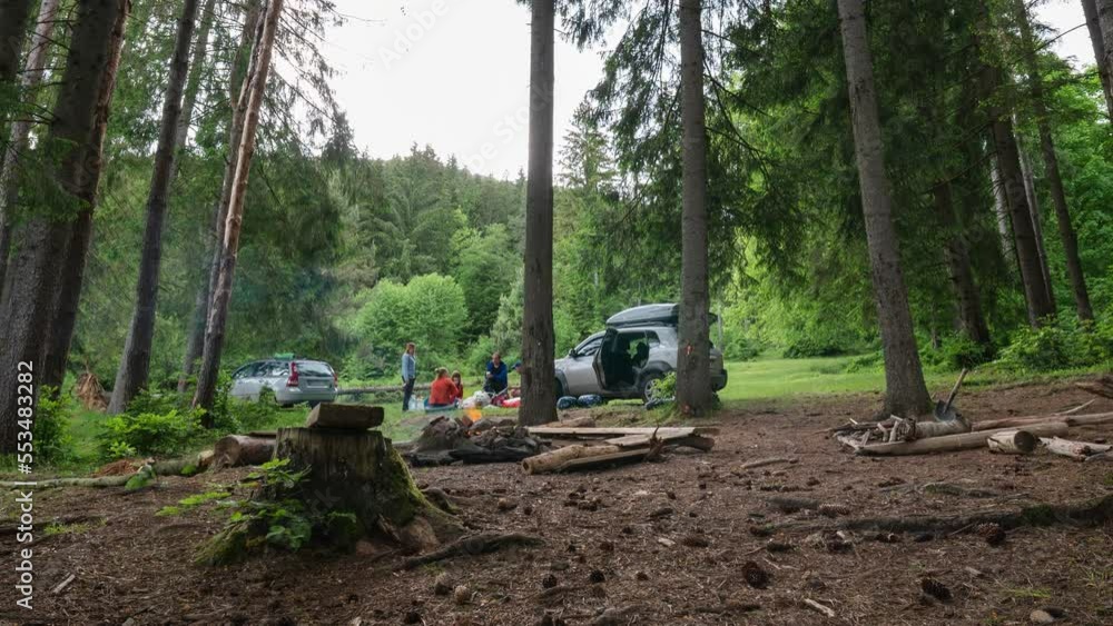 Time lapse. Men make shelter from rain and bad weather, prepare the camp. A bonfire is burning, firewood. People socialize and relax in wild conditions. Cars with roof racks. Mountains forest. Time lapse. Men make shelter from rain and bad weather, prepare the camp. A bonfire is burning, firewood. People socialize and relax in wild conditions. Cars with roof racks. Mountains forest.