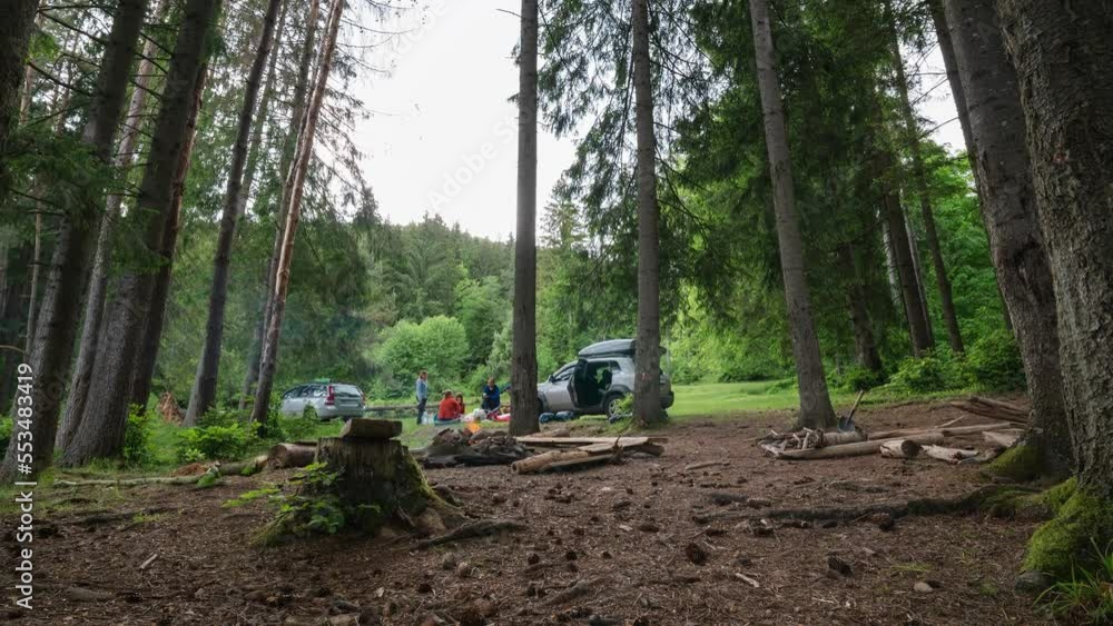 Time lapse. Men make shelter from rain and bad weather, prepare the camp. A bonfire is burning, firewood. People socialize and relax in wild conditions. Cars with roof racks. Mountains forest. Time lapse. Men make shelter from rain and bad weather, prepare the camp. A bonfire is burning, firewood. People socialize and relax in wild conditions. Cars with roof racks. Mountains forest.