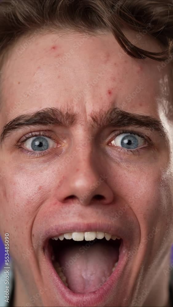 Vertical video slow motion closeup portrait of amazed young man 20s shocked, saying WOW. Handsome guy surprised isolated on solid purple background. Vertical video slow motion closeup portrait of amazed young man 20s shocked, saying WOW. Handsome guy surprised isolated on solid purple background.